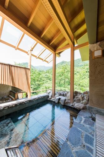 an indoor swimming pool in a house with a view at Bettei Senjyuan in Minakami