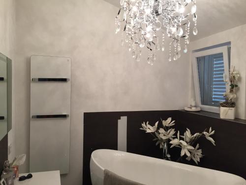 a bathroom with a bath tub and a chandelier at Villa Niki in Soline