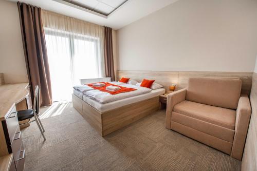 Habitación de hotel con cama y silla en AQUA SPORT*** en Púchov
