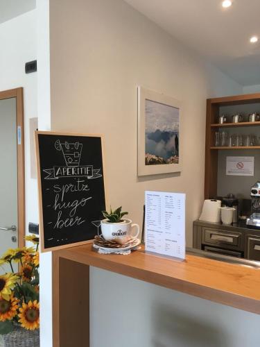 a counter with a sign and a coffee cup on it at Hotel Villa Al Vento in Nago-Torbole