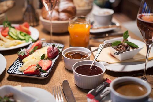 a wooden table topped with plates of food and drinks at Landgasthof & Restaurant Batzenhäusl in Sankt Gilgen