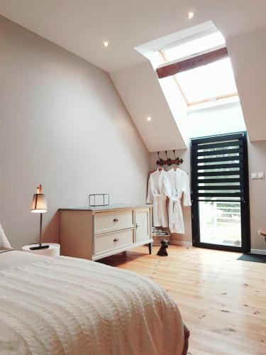 a bedroom with a bed and a dresser and a window at Domaine du bois Chaumet in Couzon