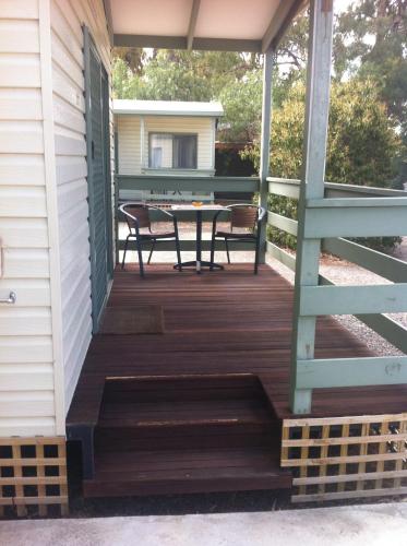a deck with a table and chairs on a house at Golden Country Motel and Caravan Park in Maryborough