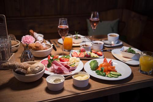 a table with plates of food and glasses of wine at Landgasthof & Restaurant Batzenhäusl in Sankt Gilgen