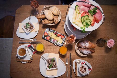 a wooden table with plates of food on it at Landgasthof & Restaurant Batzenhäusl in Sankt Gilgen