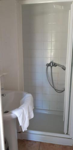 y baño blanco con bañera y ducha. en Casa San Salvadore en Favalello