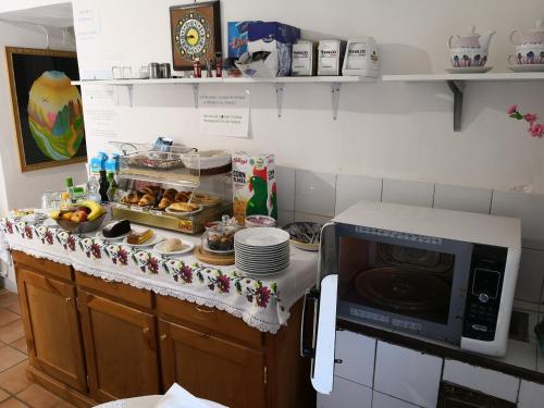a kitchen counter with a microwave and some food at Palazzo Della Marra in Ravello