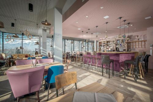 um restaurante com cadeiras roxas e um bar em Cubo Sport & Art Hotel em Sankt Johann in Tirol