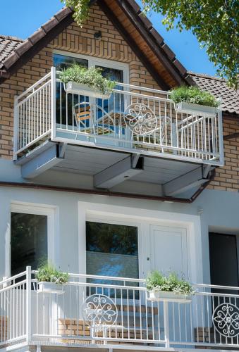 a house with a balcony with plants on it at Orbisa Pokoje i Apartamenty in Łeba