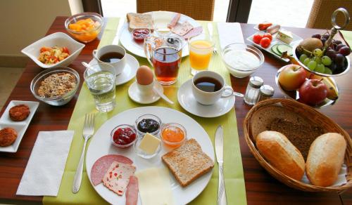 een tafel met borden vol ontbijtproducten en drankjes bij Landhaus Heinrichshof in Jüterbog