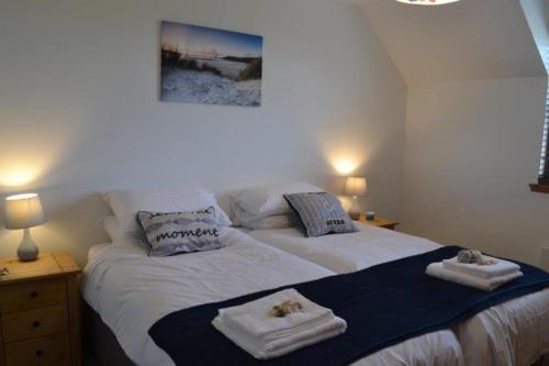 a bedroom with a bed with towels on it at Beach View in Nairn