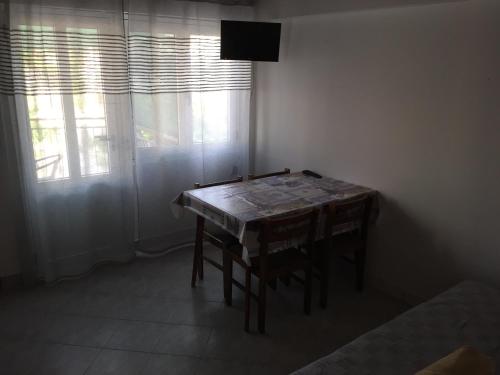 a table in a room with a television and a window at Jerkovic Apartment in Žuljana