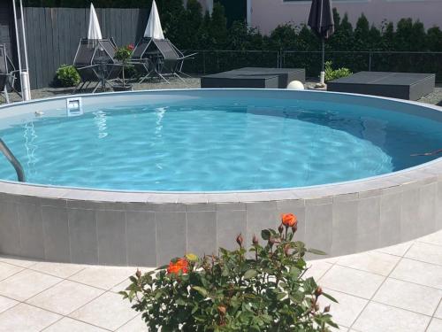 a large circular swimming pool with blue water at Enjoyit Rooms in Velden am Wörthersee