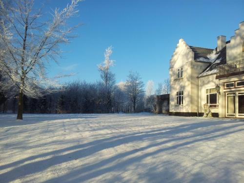 a snow covered yard in front of a house at Gørdinglund Herregård Bed & Breakfast in Gørding
