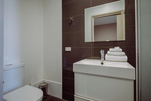 ナラブライにあるCrossroads Hotelのバスルーム(洗面台、トイレ、鏡付)
