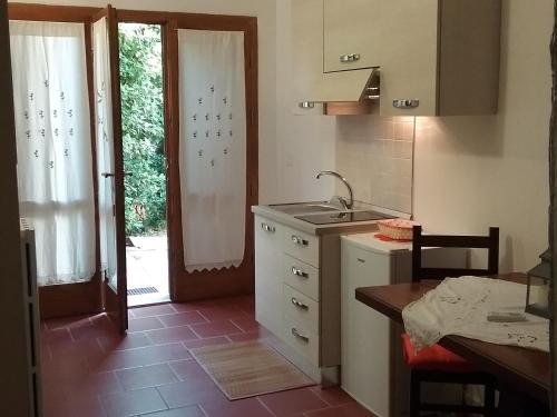 una cucina con lavandino e una porta per un cortile di Camere Il Meoccio a Manciano