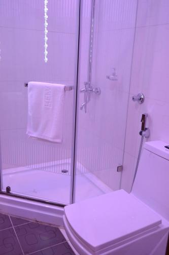 a white bathroom with a shower and a toilet at Refal Homes in Jeddah