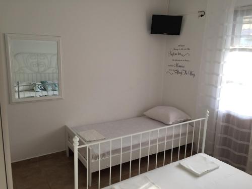 a room with a crib with a tv on the wall at Jerkovic Apartment in Žuljana
