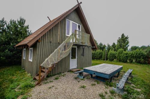a small house with a picnic table in front of it at Rusnietis in Rusnė