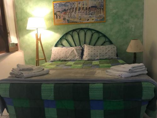 a bedroom with a large bed with a green headboard at Casa La Pelosa Beach in Stintino