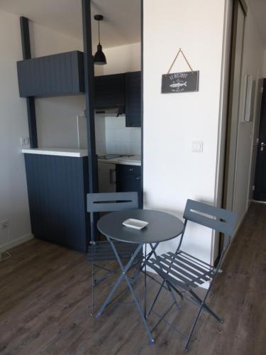 ラ・ロシェルにあるFace à la Plage des Minimes PONANT 3 Appt 407のキッチン付きの客室で、テーブルと椅子が備わります。