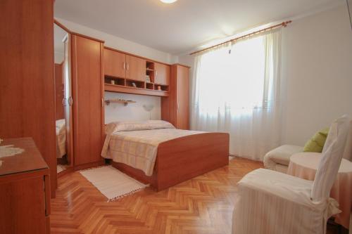 een slaapkamer met een bed, een bank en een raam bij Nerina in Novigrad Istria