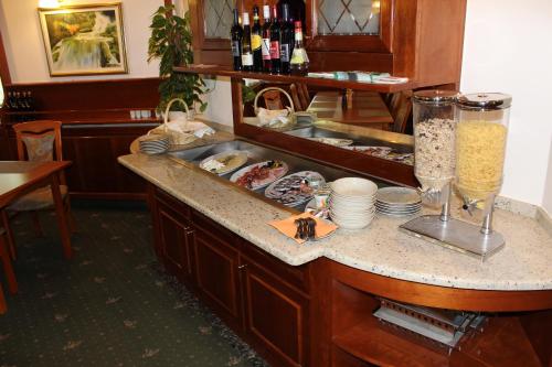 Un bar con un mostrador con platos y botellas de vino. en Guesthouse Veranda, en Mojstrana