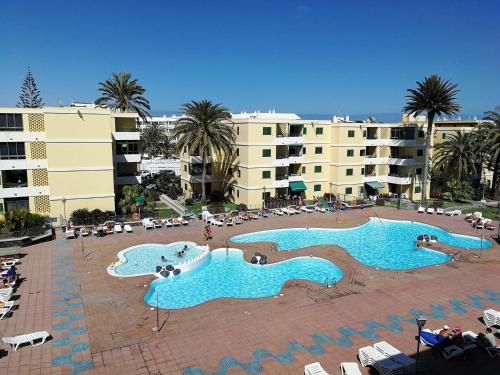 Blick auf zwei Swimmingpools in einem Resort in der Unterkunft HUELLA CANARIA Complejo LAS OLAS in Playa del Ingles