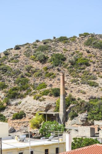 a building with a chimney in front of a hill at Kalypso in Agia Galini