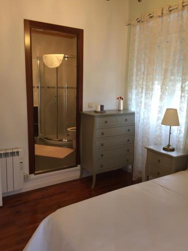 ein Schlafzimmer mit einem Bett, einer Kommode und einer Dusche in der Unterkunft Casa Os Loureiros in Muros