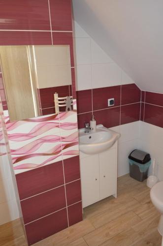 a small bathroom with a sink and a mirror at Pokoje na Wzgórzu in Kasina Wielka