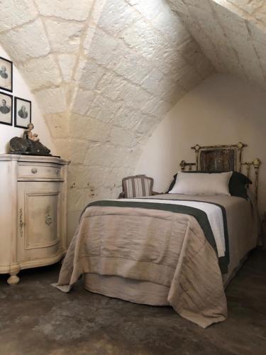 a bedroom with a bed and a dresser at Antica Dimora Giardini Segreti in Giuggianello