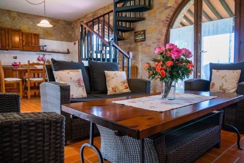 a dining room with a table with flowers on it at Pian della Casa in Montaione