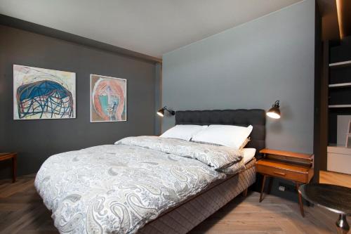 ein Schlafzimmer mit einem Bett und zwei Gemälden an der Wand in der Unterkunft Ocean View Luxury Apartment in Central Reykjavik in Reykjavík