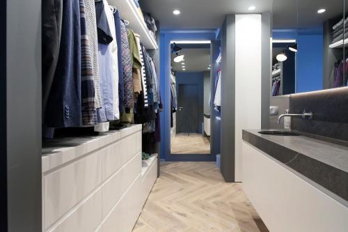 einen begehbaren Kleiderschrank mit einem Waschbecken und einem Spiegel in der Unterkunft Ocean View Luxury Apartment in Central Reykjavik in Reykjavík