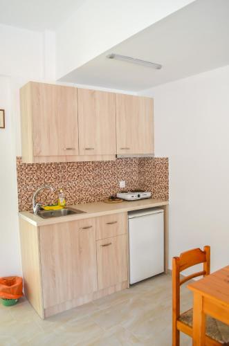 a kitchen with wooden cabinets and a sink and a table at Kalypso in Agia Galini