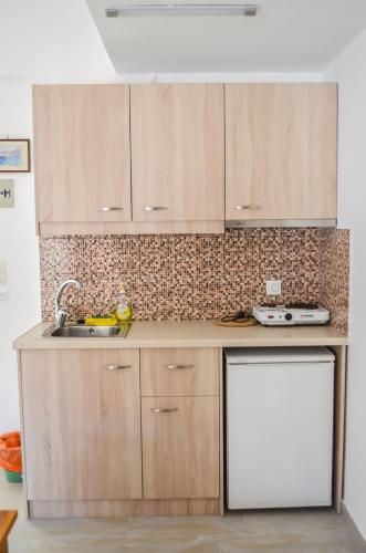 a kitchen with wooden cabinets and a sink at Kalypso in Agia Galini