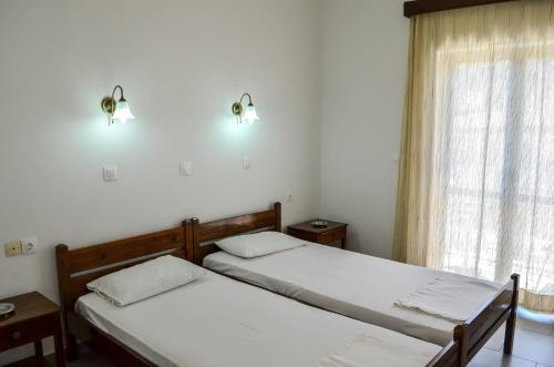 two twin beds in a room with a window at Kalypso in Agia Galini