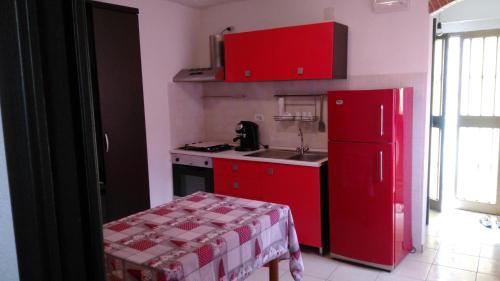 cocina con armarios rojos y nevera roja en Casa Vacanze Margherita - Sasso di Castalda en Sasso di Castalda