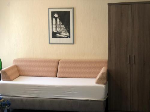 un sofá en una habitación con una foto en la pared en Hotel Junkerhaus, en Bad Salzuflen