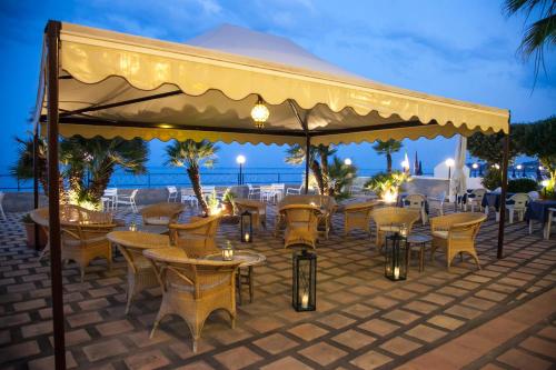a restaurant with tables and chairs under a canopy at Park Hotel Silemi in Letojanni