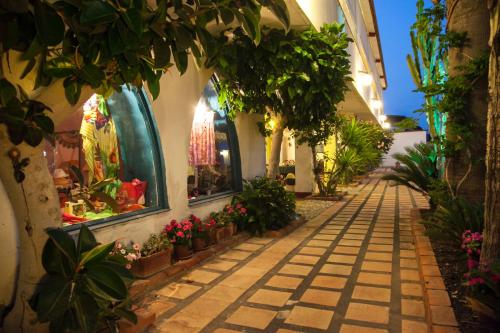 an alley with plants and flowers in a building at Park Hotel Silemi in Letojanni