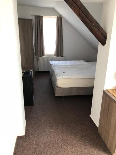 a bedroom with a bed and a window at Hotel Junkerhaus in Bad Salzuflen
