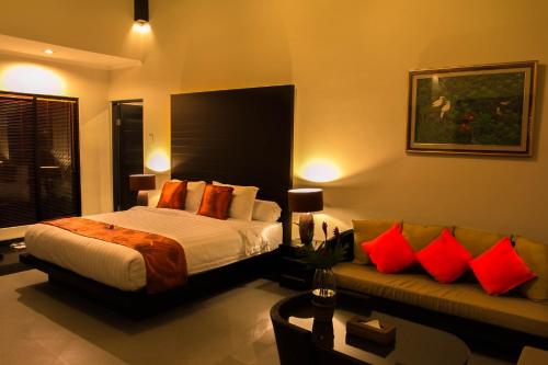 a bedroom with a bed and a couch at Askara Villa in Canggu