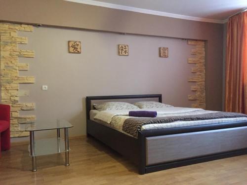 1 dormitorio con 1 cama y 1 mesa en Uzh Apartments, en Uzhhorod