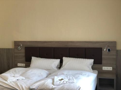 a bed with white sheets and towels on it at Hotel Junkerhaus in Bad Salzuflen