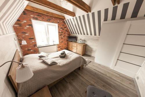 グダニスクにあるEuro Apartments Motlavaのレンガの壁、ベッド付きのベッドルーム1室
