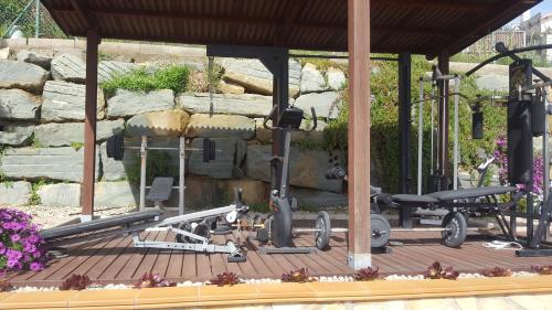 a wooden deck with a bench and a stone wall at Villa SportLife in Lloret de Mar