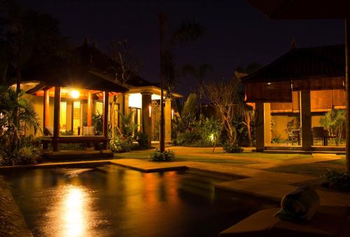 a house with a swimming pool at night at Askara Villa in Canggu