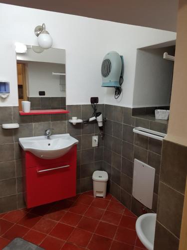 baño con lavabo rojo y aseo en Casa Vacanze IL SEDILE en Oria